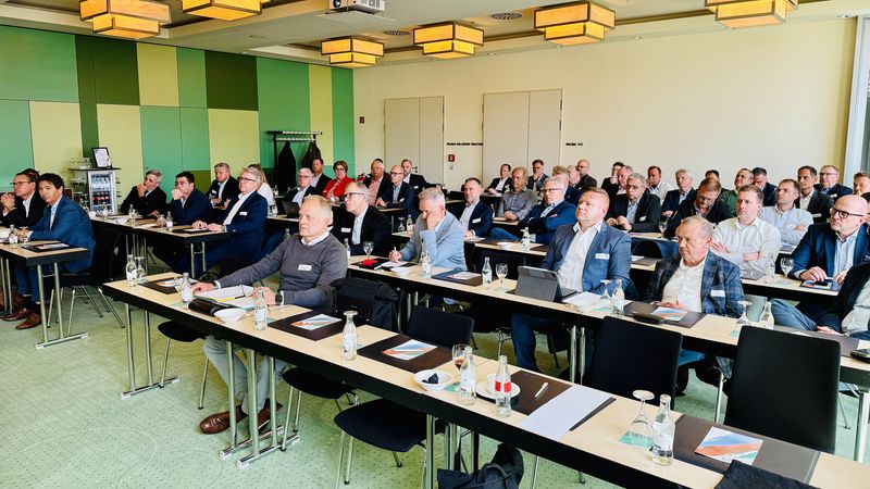 Teilnehmer einer Business-Konferenz sitzen aufmerksam in einem Konferenzraum.