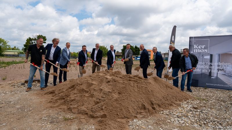 Eine Gruppe von Menschen führt eine Spatenstich-Zeremonie für ein neues Bauprojekt durch.