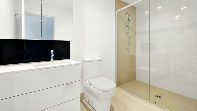 Ein modernes Badezimmer mit einer großen, gläsernen Dusche und einem weißen Waschtisch.