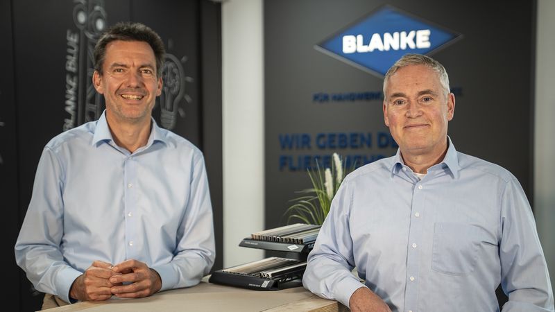 Zwei Männer stehen vor dem Blanke-Logo an einem langen Stehtisch