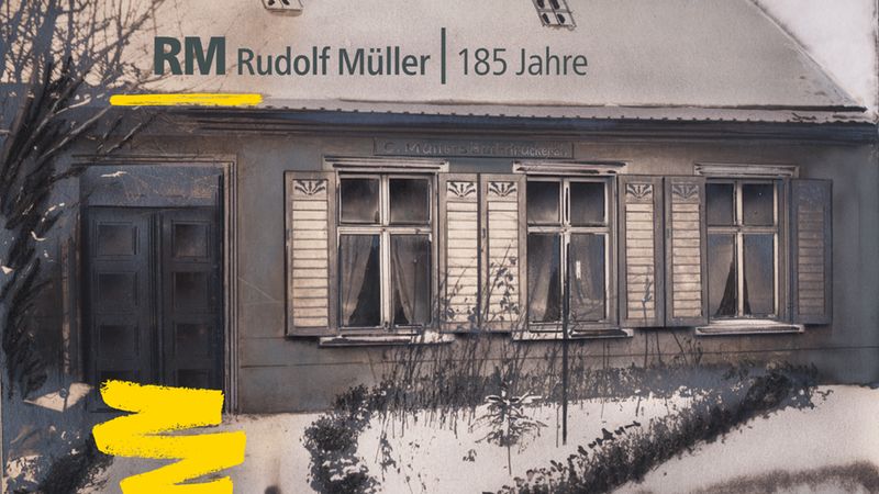Ein historisches Gebäude mit der Aufschrift "Rudolf Müller 185 Jahre" auf dem Dach.