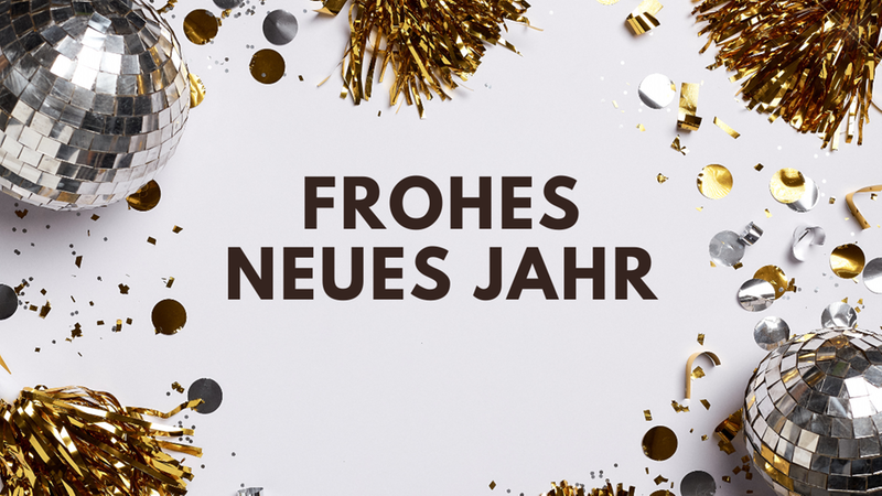 Ein Bild mit dem Schriftzug "Frohes Neues Jahr" umgeben von goldenen und silbernen Disco-Kugeln und Konfetti.
