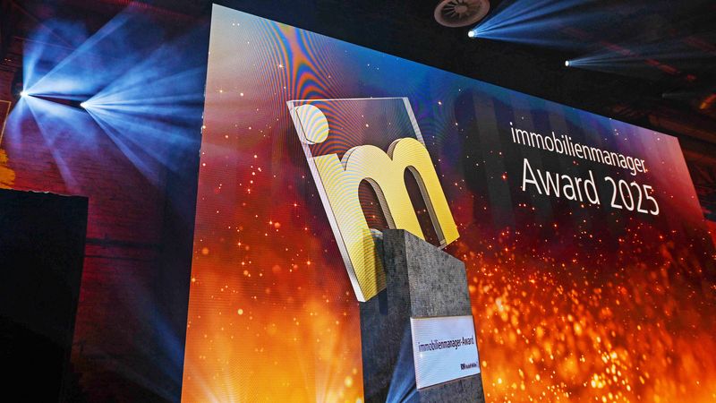Die Bühne des Immobilienmanager Award 2025 mit beleuchtetem Logo und Lichteffekten.