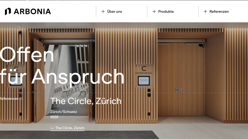 Der Eingang zum Convention Hall im The Circle, Zürich, mit moderner Holzverkleidung und offener Tür.