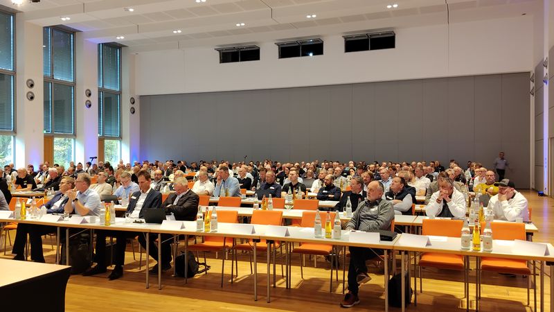 Ein großer Konferenzraum mit vielen Teilnehmern, die an einem Seminar teilnehmen.