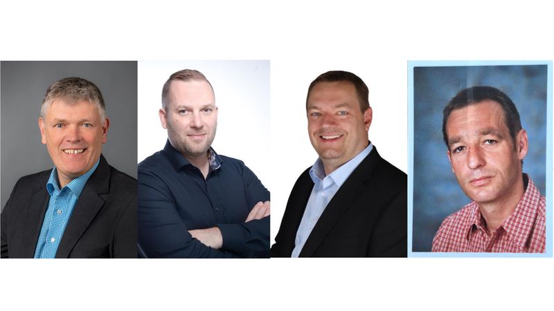 Ein Gruppenfoto von vier Männern in formeller Kleidung.