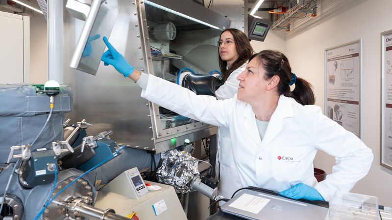 Zwei Wissenschaftlerinnen arbeiten in einem modernen Labor an einem technischen Gerät.