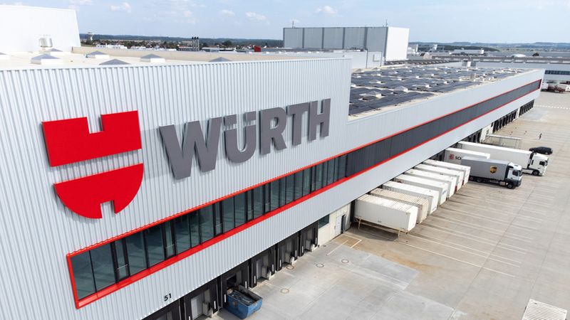 Das Bild zeigt das moderne Logistikzentrum von Würth mit mehreren LKWs und Ladebereichen.