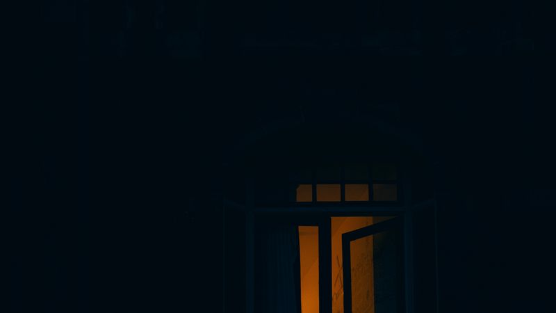 Ein einzelnes, beleuchtetes Fenster in einem dunklen Gebäude bei Nacht. Quelle: Foto von Paul Lichtblau auf Unsplash