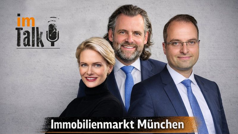 Eine Talkrunde über den Immobilienmarkt in München mit drei Personen in Businesskleidung vor einem grauen Hintergrund.