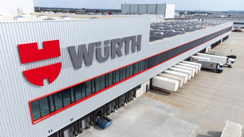 Das Bild zeigt das moderne Logistikzentrum von Würth mit mehreren LKWs und Ladebereichen.