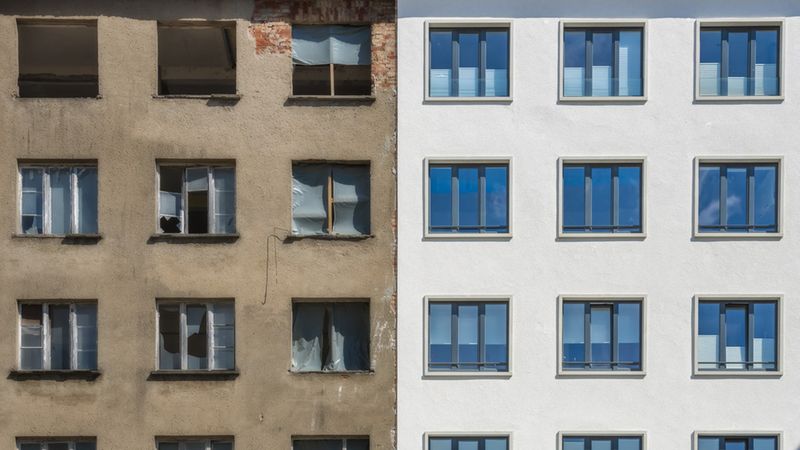 Ein Gebäude, das zur Hälfte renoviert ist: links alt und verfallen, rechts modern und erneuert.