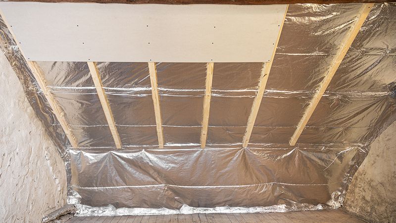 Ein Dachboden mit einer Reflexionsdämmung, die an der Decke angebracht ist.