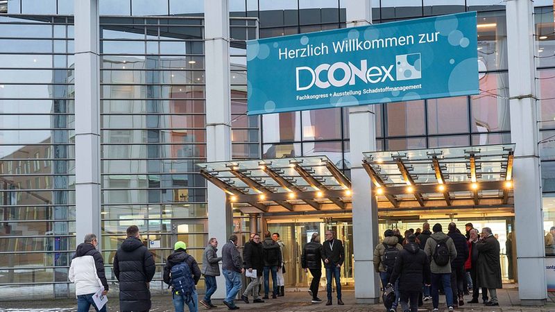Menschen betreten das Kongresszentrum zur DCONex-Fachmesse.