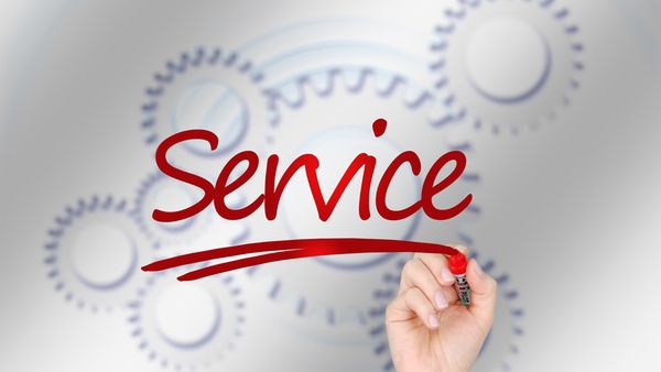 Symbolbild zum Thema Service, Schriftzug Service vor Zahnrädern