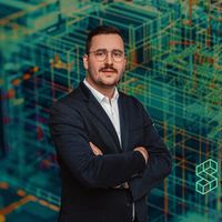 Ein Mann im Anzug steht vor einem digitalen Architekturmodell, das im Hintergrund zu sehen ist.