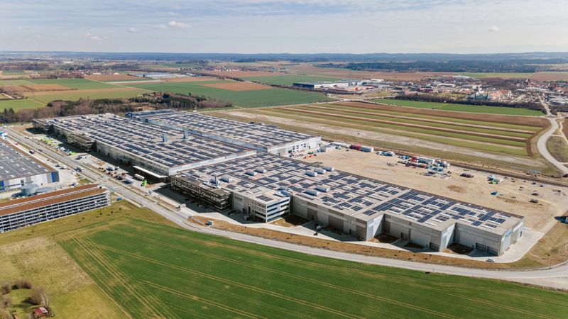Luftaufnahme einer großen Industrieanlage inmitten einer ländlichen Umgebung mit Feldern und Straßen.