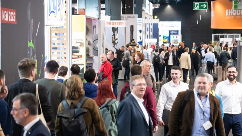 Besucher auf einer Industriemesse, die sich durch die Ausstellungshallen bewegen.