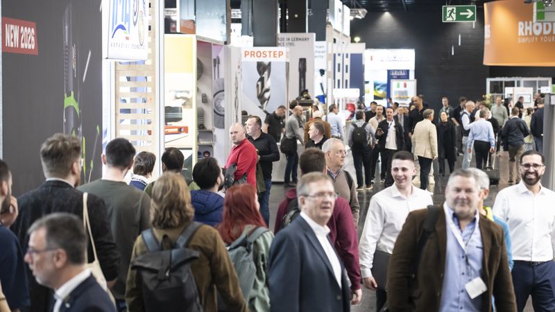 Besucher auf einer Industriemesse, die sich durch die Ausstellungshallen bewegen.