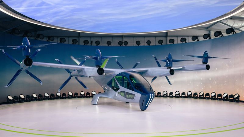 Ein modernes elektrisches Flugtaxi steht in einem futuristischen Hangar, umgeben von Beleuchtung und einer gewölbten Decke.