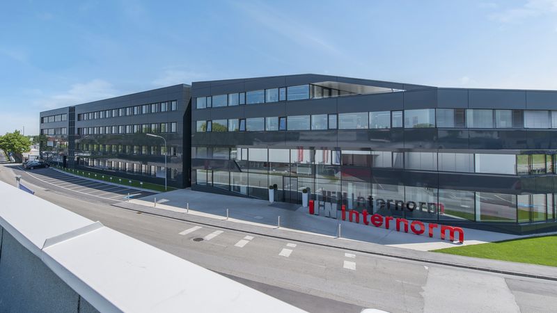 Ein modernes Bürogebäude mit großen Glasfenstern und einem klaren, minimalistischen Design.