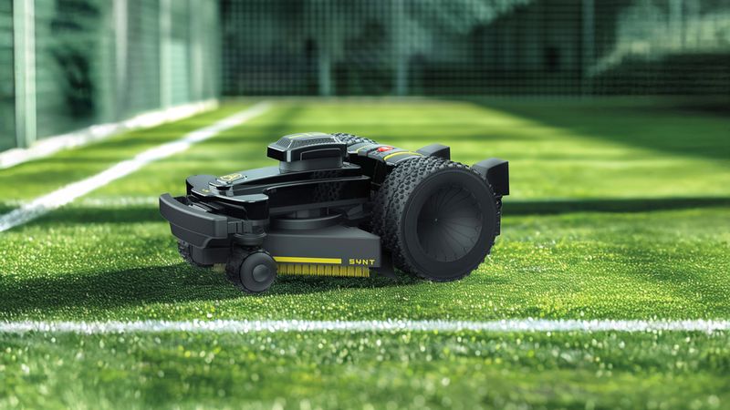 Ein moderner Rasenmähroboter mäht das Gras in einem Fußballstadion.