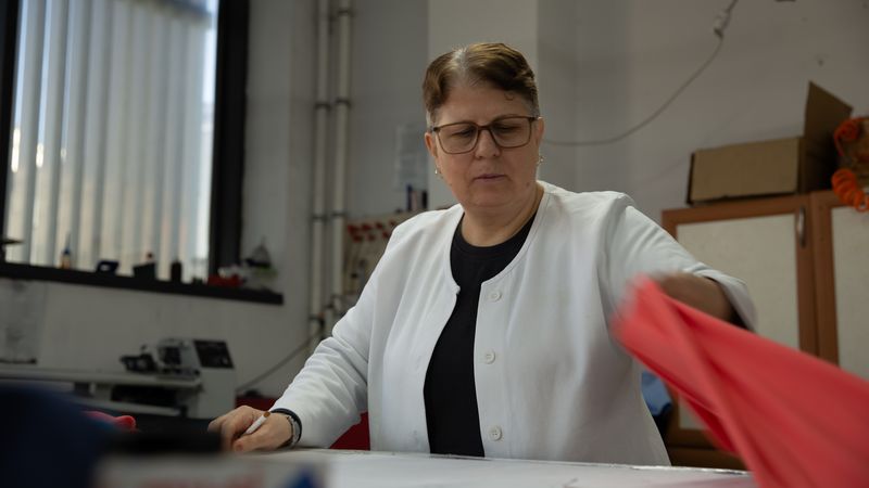 Eine Frau arbeitet konzentriert in einem Büro, umgeben von Büroausstattung.