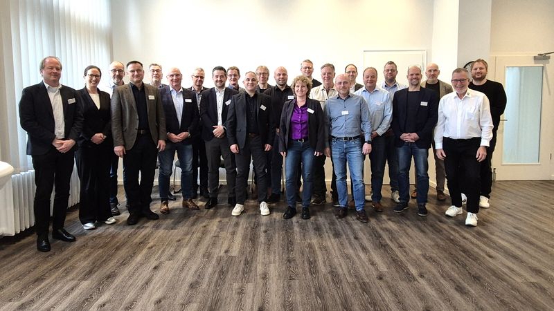 Ein Gruppenfoto von Personen, die in einem Konferenzraum stehen.
