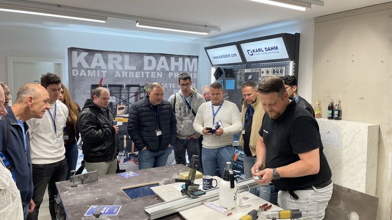 Eine Gruppe von Menschen beobachtet eine Werkzeugschulung in einem Raum mit verschiedenen Werkzeugen und Materialien.