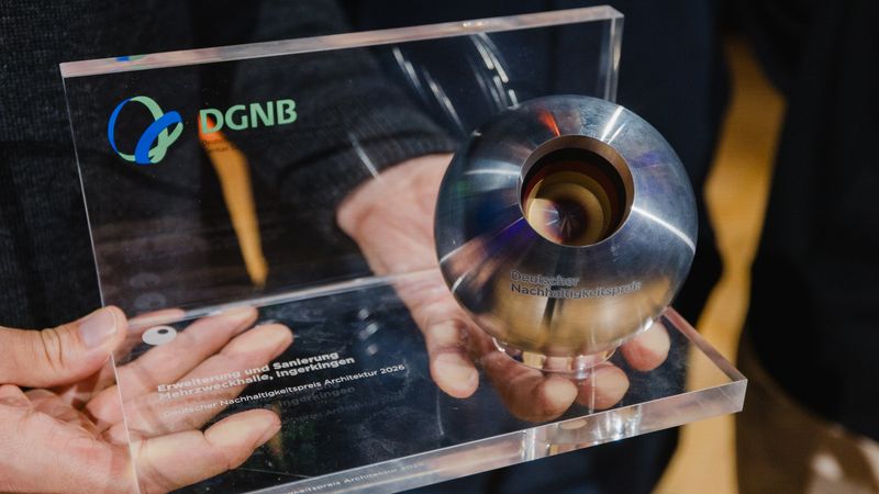 Die Trophäe des Deutschen Nachhaltigkeitspreises wird in den Händen gehalten.