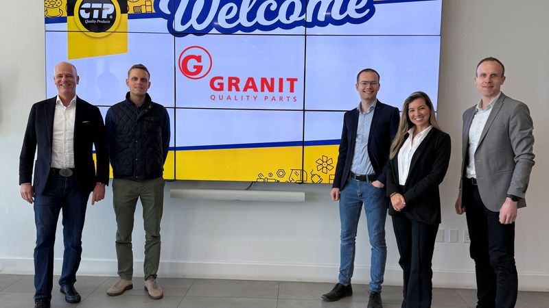 Eine Gruppe von fünf Personen steht vor einem großen digitalen Willkommensschild mit den Logos von CTP und Granit Quality Parts.