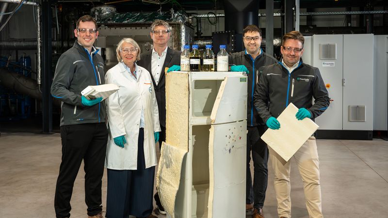 Ein Forscherteam präsentiert ein Recyclingprojekt, bei dem Materialien aus einem alten Kühlschrank wiederverwendet werden.