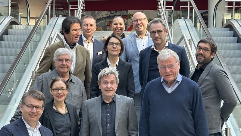 Eine Gruppe von Menschen steht auf einer Treppe in einem modernen Gebäude.