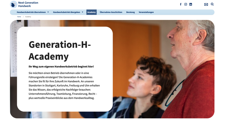 Ein älterer Mann und eine jüngere Frau betrachten gemeinsam Informationen auf einem Bildschirm in der Generation-H-Academy.