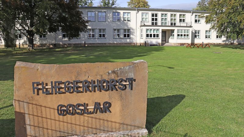 Ein Gebäude des Fliegerhorsts Goslar mit einem großen Stein im Vordergrund, auf dem "Fliegerhorst Goslar" steht.
