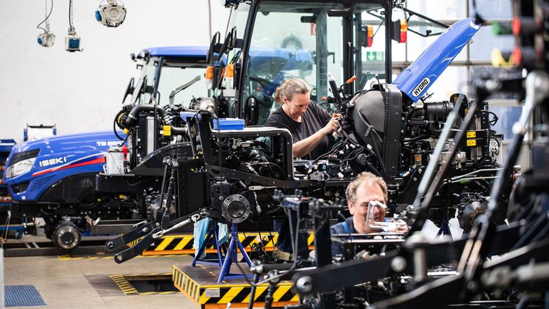 Ein Mechaniker arbeitet in einer Werkstatt an der Montage eines Traktors.