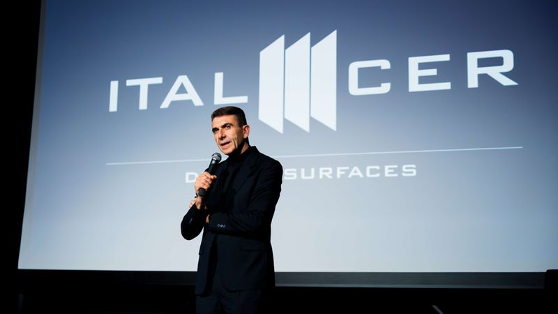 Ein Mann hält eine Präsentation auf einer Bühne vor einem großen Bildschirm mit dem Logo von Italcer.