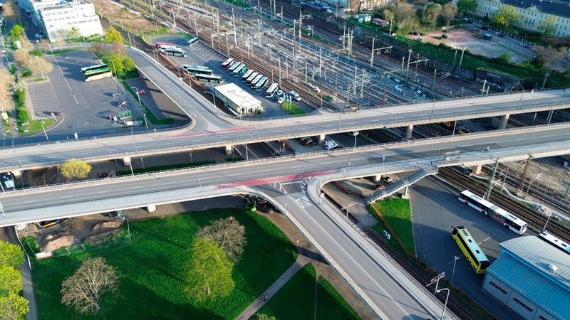 Luftaufnahme eines Verkehrsknotenpunkts mit Straßen, Brücken und einem Busbahnhof.