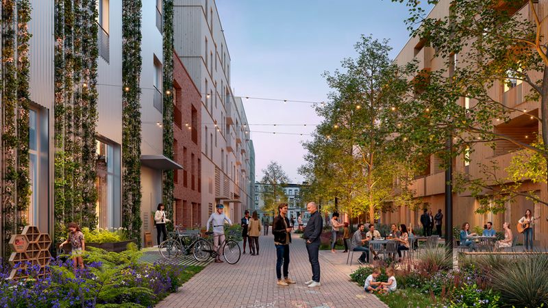 Städtischer Begegnungsraum zwischen modernen Wohngebäuden bei Abenddämmerung: Menschen unterhalten sich und sitzen an Außenplätzen von Cafés, Kinder spielen und malen mit Kreide, Fahrräder stehen an einem Abstellplatz, Lichterketten hängen über dem gepflasterten Weg. Fassaden mit Holz- und Ziegeldetails sowie vertikale Begrünung und Bäume schaffen eine nachhaltige, gemeinschaftliche Atmosphäre in diesem urbanen Wohnhof.