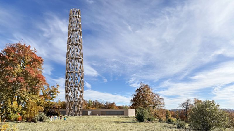 Eine architektonische Darstellung eines modernen, filigranen Aussichtsturms aus Holz, der sich vor einem herbstlichen Waldgebiet unter blauem Himmel erhebt.