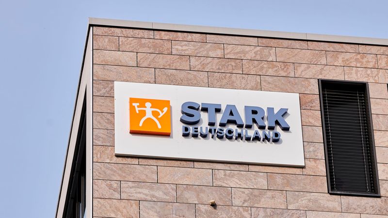 Ein Firmenlogo von STARK Deutschland an einer modern gefliesten Fassade eines Bürogebäudes.