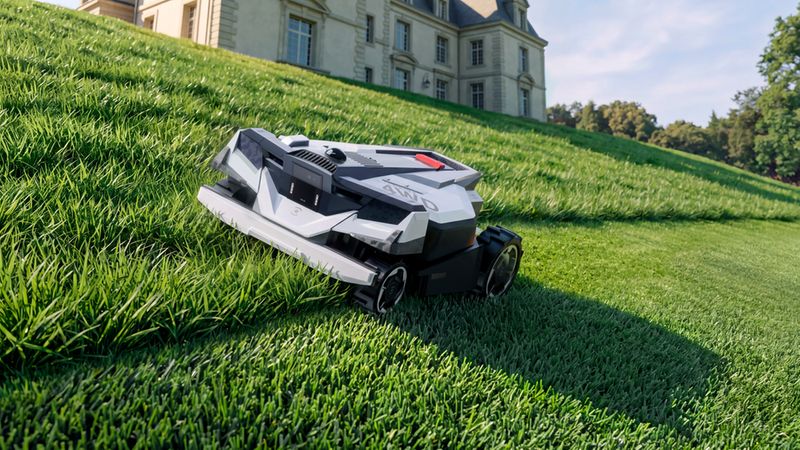 Ein moderner Mähroboter mit Allradantrieb, der effizient an einer steilen grünen Rasenfläche arbeitet, im Hintergrund ein luxuriöses Herrenhaus.