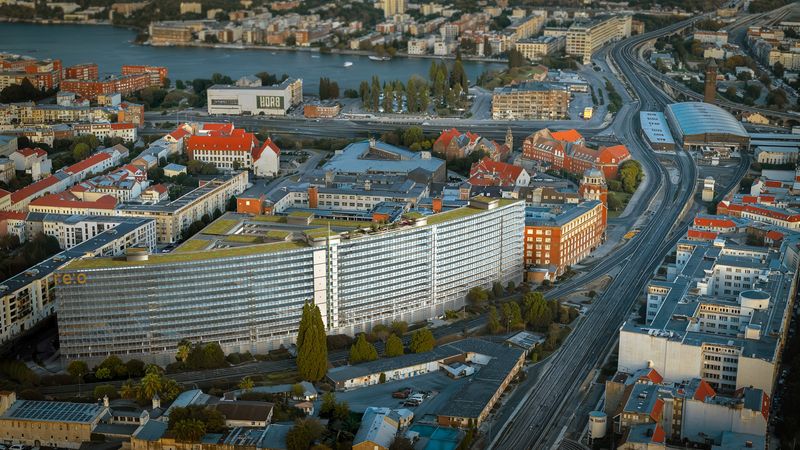 Luftaufnahme eines modernen Bürogebäudes in Berlin, umgeben von Straßen und anderen Gebäuden.