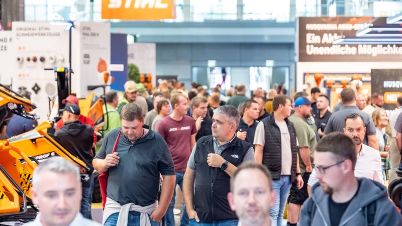 Ein belebter Gang auf einer Industriemesse mit zahlreichen Besuchern, die an Ständen namhafter Hersteller wie Stihl und Husqvarna entlanggehen.