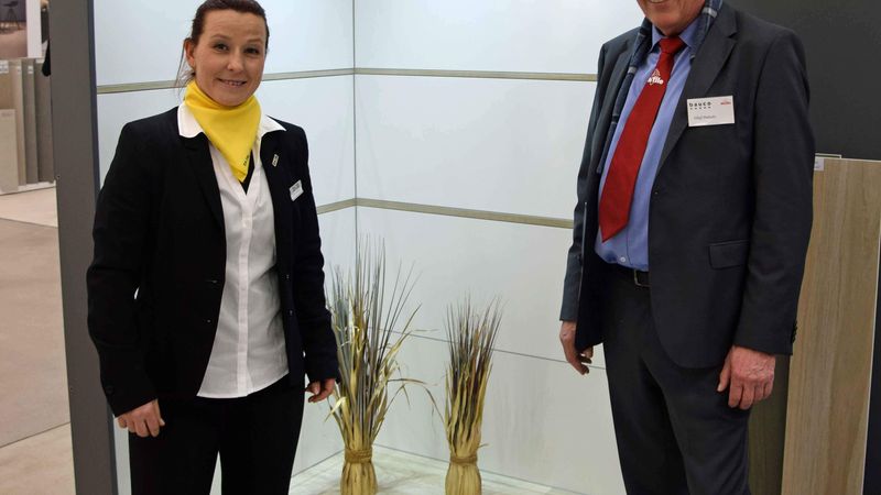 Olaf Dukatz, leitender Angestellter bei Bauco, und Simone Mienhardt von Taxis vor der Serie „Caldero“, die in weiß glänzend sowie matt erhältlich ist. Am Boden der Koje ist die Holzoptik „Cantiano“ zu sehen.