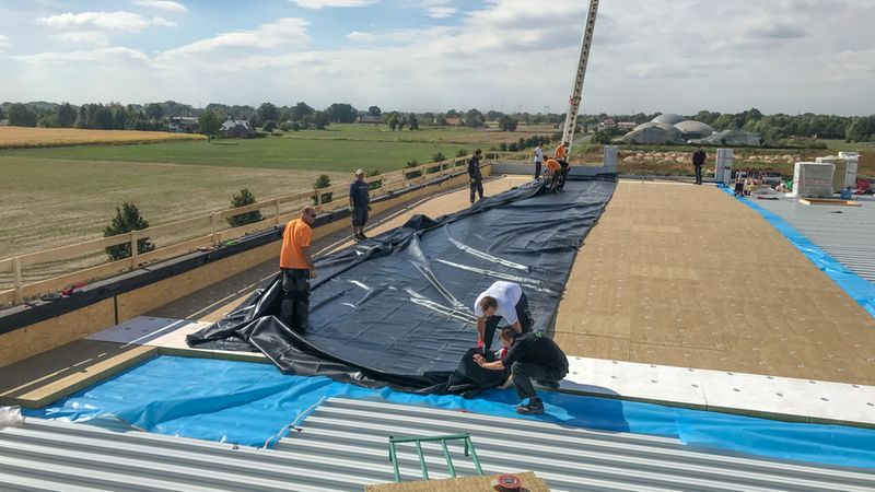 Die großflächig, vorkonfektionierten EPDM-Bahnen wurden via Baustellenkran auf das Dach gebracht und dann nach speziellem Verlegeplan platziert, ausgerollt und vom Dachdeckerteam ausgebreitet. 