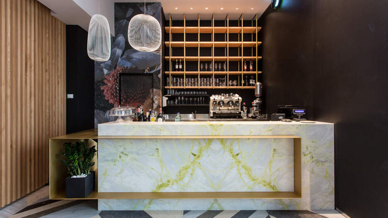 Der spiegelbildlich angebrachte Marmor „Luminous“ aus Angola – hier als vorderseitige Verkleidung der Restaurant-Bar – in seiner eleganten grün-gelben Zeichnung auf hellem Grund. 