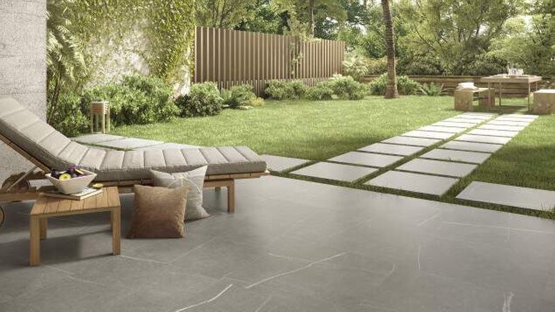 Kleinformatige Platten schaffen, dekorativ in Rasen oder Kies eingebettet, optische Highlights. (Foto: Tile of Spain/Colorker)<br>