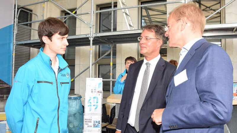 Felix Pakleppa (rechts), der Hauptgeschäftsführer des ZDB, und der für das Bauen zuständige Staatssekretär Gunther Adler (Mitte) im Gespräch mit Cedrik Knöpfle 