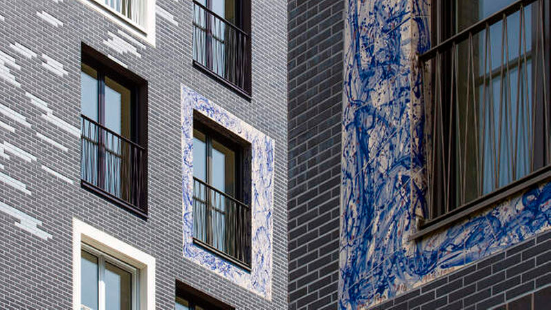 Die farblich variable Fassade und die mit der Hand dekorierte Keramik um die Fenster prägen das Erscheinungsbild der Gebäude.